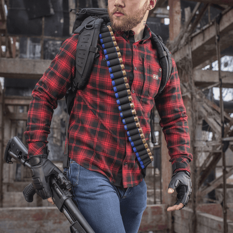 Metsästäjä M-Tac Bandolier Elite täynnä kaliberin 12/16 patruunoita, valmiina metsästykseen hylätyssä rakennuksessa.