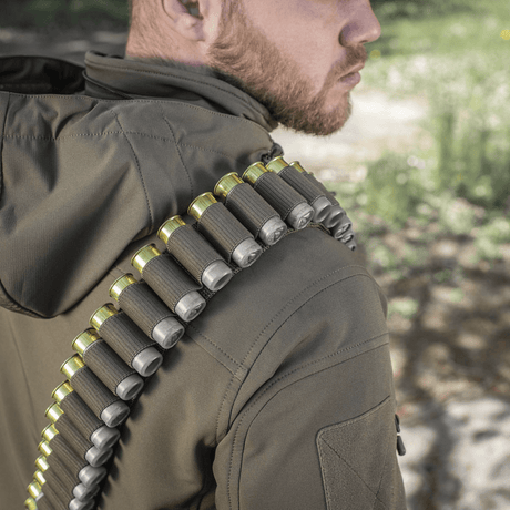 Henkilö kantaa M-Tac Bandolier Elitea, näyttää patruunavyön metsästykseen ja ampumaurheiluun. Käytännöllinen muotoilu, kapasiteetti 55 patruunaa.