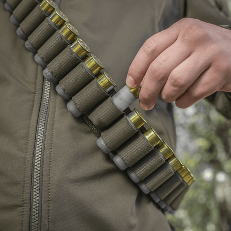 Henkilö pukeutuneena M-Tac Bandolier Eliteen täynnä ammuksia metsästykseen ja ampumaurheiluun.