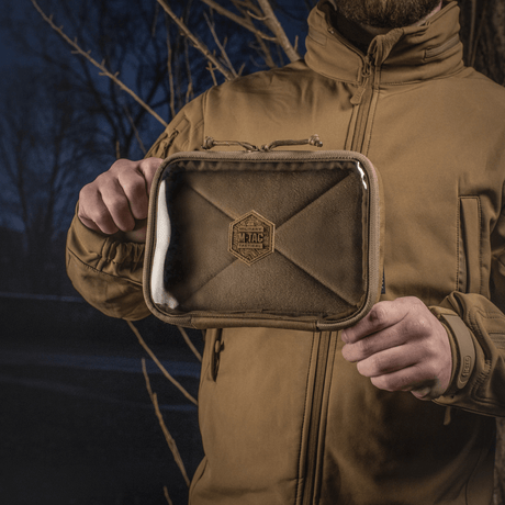 Henkilö pitelee M-Tac Utility Organizer Slim Eliteä läpinäkyvällä etuseinällä, ihanteellinen tärkeiden esineiden järjestelmälliseen säilytykseen, valmistettu tukevasta Cordura 500D:stä