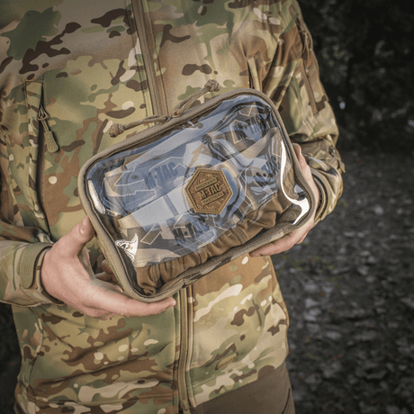 M-Tac Utility Organizer Slim Elite maastokuvioituna, henkilön pitämä, näyttää kestävän Cordura 500D:n ja PVC-kalvon nopeaan tunnistukseen.