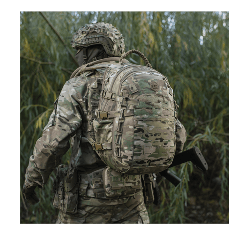 M-Tac Mission Pack Elite reppu camo-kuvioituna, MOLLE LASER CUT-system metsäalueella.