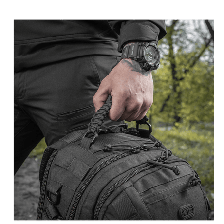 Mies pitää M-Tac Mission Pack Elite -reppua, jossa MOLLE LASER CUT-system ja Cordura 1000D -materiaali.