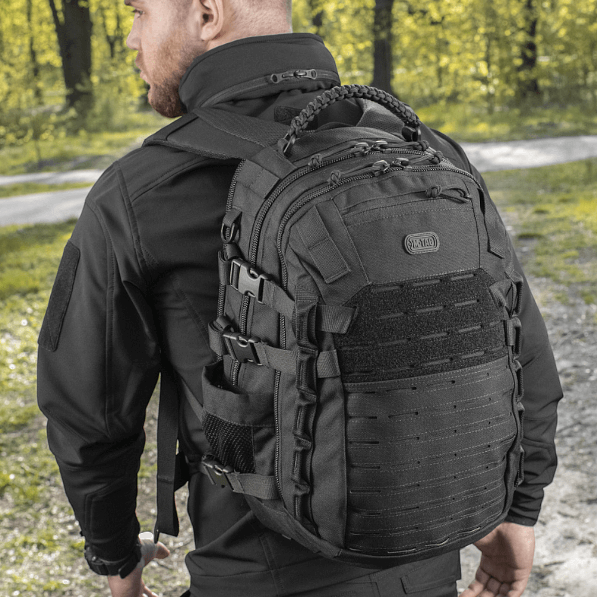 M-Tac Mission Pack Elite rygsæk med slidstærkt Cordura 1000D og MOLLE LASER CUT-system i skovmiljø