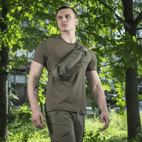 Mies käyttää M‑Tac Bæltetaske Elite Hexiä luonnossa, sopii arkeen, Cordura 500D ja Woojin-soljet näkyvissä.