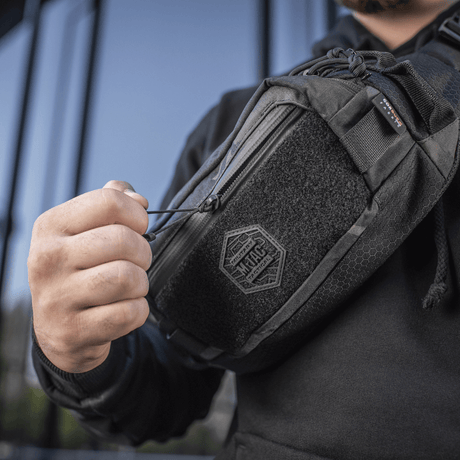 M-Tac Elite Hex -vyölaukku käytössä, näyttää kestävän muotoilun Cordura-kankaasta, YKK-vetoketju ja Woojin-soljet, sopii arkeen.