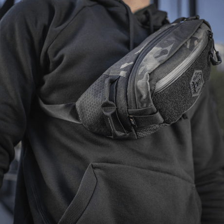 M-Tac Elite Hex -vyölaukku mustana, Cordura-materiaali ja YKK-vetoketjut, kannettuna arjessa tai taktiseen varustukseen.