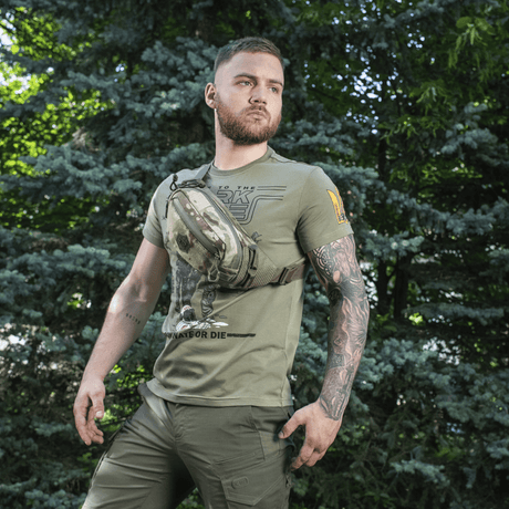 Mies käyttää M‑Tac Elite Hex -vyölaukkua ulkoilmassa, sopii arkeen ja taktisiin tarkoituksiin, valmistettu kestävästä Cordura-materiaalista.
