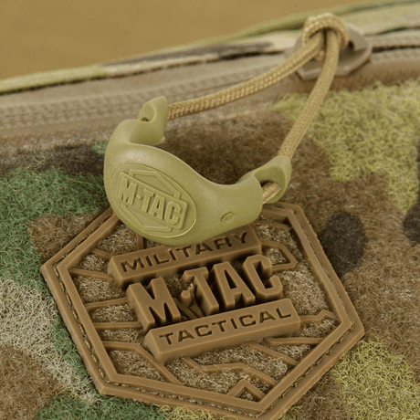 M‑Tac Elite Hex -lähikuva logosta ja vetoketjun yksityiskohdista taktillisessa muotoilussa, sopii arkeen tai varustukseen.