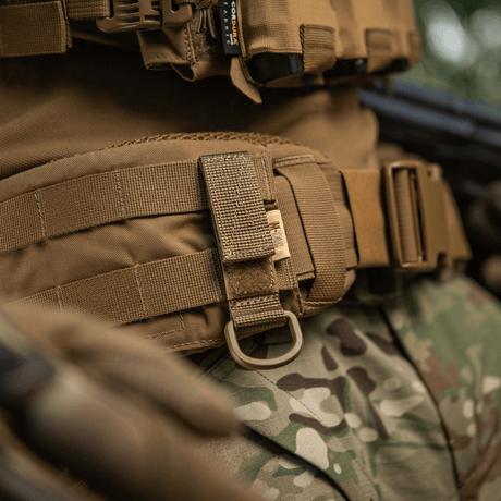 M-Tac D-ring-kiinnike MOLLE-järjestelmään taktiseen varustukseen, esittelee luotettavan ripustuksen ja säädettävän Velcro-lukituksen.