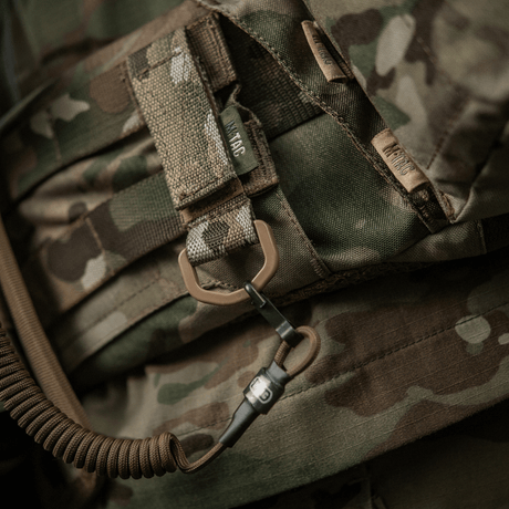 M-Tac-kiinnike D-renkaalla camo-repussa, sopii taktiseen käyttöön MOLLE-järjestelmän kanssa. Velcro-suljin, kompakti ja kevyt muotoilu.