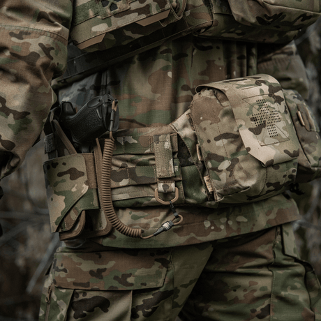 M-Tac-kiinnike D-renkaalla asennettuna camouflage-varusteeseen MOLLE-järjestelmässä.
