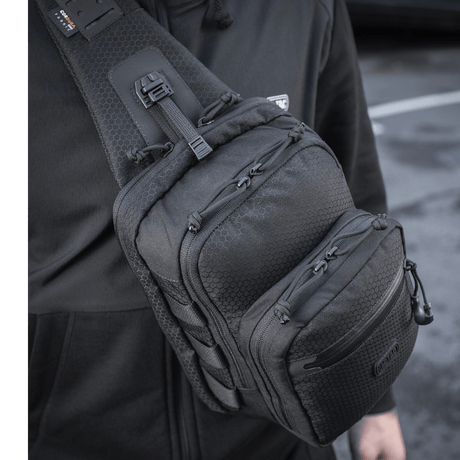 Mies kantaa M-Tac Cross Taske Slim Elite Hex -laukkua mustana olallaan.
