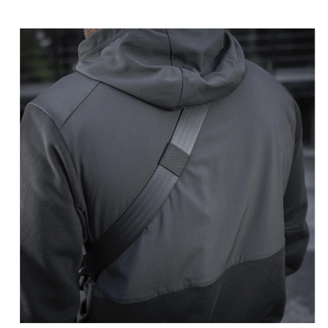 Henkilö, jolla on M-Tac Cross Taske Slim Elite Hex ja musta takki.