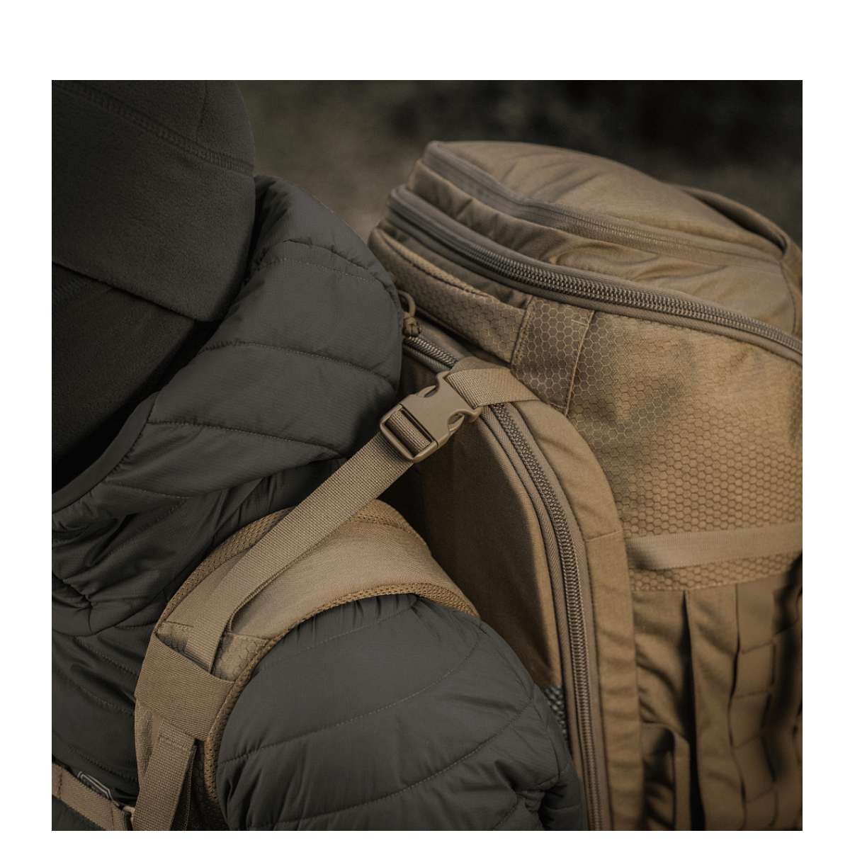 Person med M-Tac Rygsæk Large Elite Hex Gen. IV, ergonomisk og funktionel, designet til at bære våben, lavet af slidstærk Cordura.