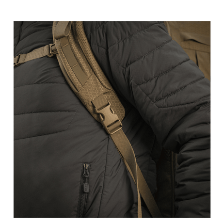 Henkilö mustassa takissa kantaa M-Tac reppu Large Elite Hex Gen. IV säädettävillä remmeillä ja ergonomisella muotoilulla.