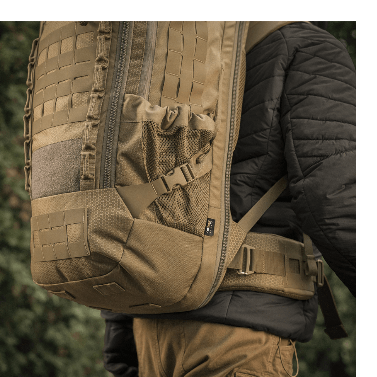 M-Tac Rygsæk Large Elite Hex Gen. IV bæres af person, ergonomisk design, lavet af slidstærk Cordura 500D og Hex 1000 materiale.