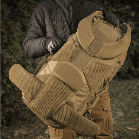 Henkilö pitää M-Tac reppu Large Elite Hex Gen. IV, tehty tukevista materiaaleista, sopii aseiden kantamiseen luonnossa.