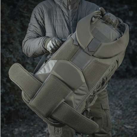 M-Tac reppu Large Elite Hex Gen. IV tukevasta Cordura-materiaalista, ergonominen muotoilu, esillä ulkoilmassa, kantajana henkilö.