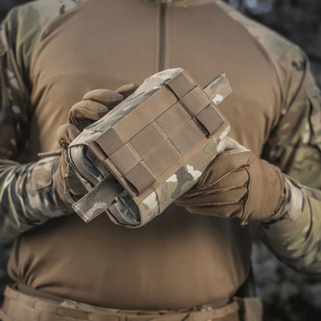 M-Tac Horisontal Medic Lomme Large Elite multicam-materiaalissa, NIJ-sertifiointi, galleria-asento 1, käsissä taktisen varustuksen kanssa.