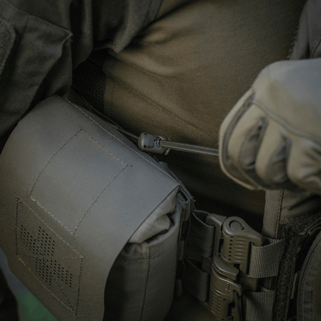M‑Tac Medic Pouch Vertical Large Elite fastgjort til taktisk udstyr, fremstillet af holdbar Cordura 500D, viser sikker opbevaring af medicinsk udstyr.