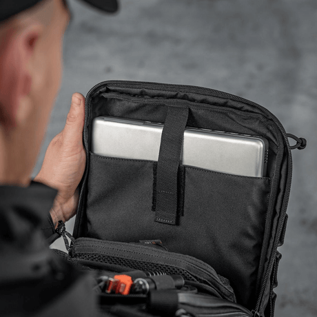 Person åbner M-Tac Tablet Bag Laser Cut Hex med tablet indeni, viser rum til hurtig adgang og dokumenter.