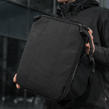 M-Tac Tablet Bag Laser Cut Hex, praktisk taske i Cordura med Laser Cut MOLLE og rum til skjult våben, set i hånd.