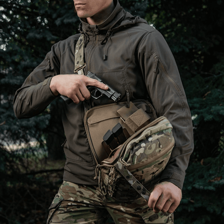 M-Tac Tablet Bag Laser Cut Hex i brug til skjult våben med hurtig adgang, camouflage design, mand iført taktisk tøj.