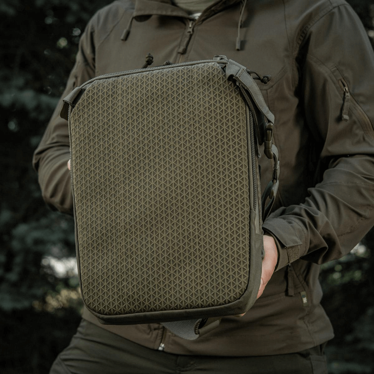 M-Tac Tablet Bag Laser Cut Hex holdt af person, lavet i Cordura, med MOLLE frontpanel, ideel til EDC, tablets og dokumenter.
