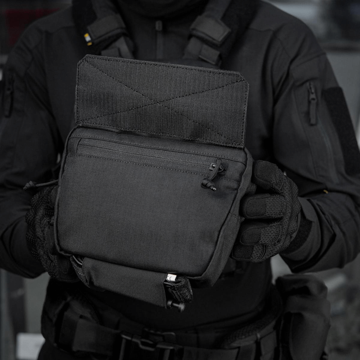M-Tac Large Elite Gen.II Skuldertaske i brug, holdt af en person iført taktisk tøj. Fremstillet af slidstærk Cordura 500D til taktisk brug.