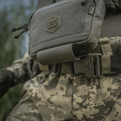 M-Tac Large Elite Gen.II Skuldertaske på militæruniform, tæt billede. Cordura 500D materiale med YKK lynlåse og front Velcro-panel.