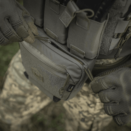 M-Tac Large Elite Gen.II Skuldertaske i Cordura 500D materiale, brugt udendørs, viser taskens holdbarhed og lynlås funktionalitet.