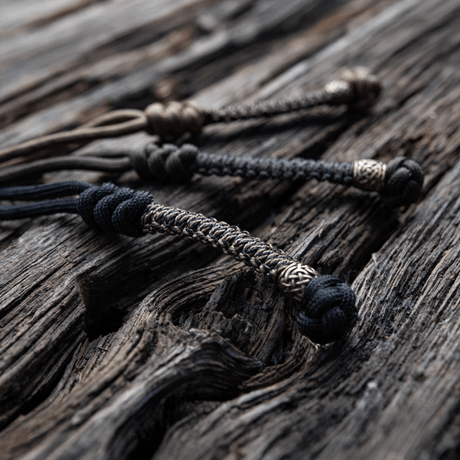 M-Tac Knife Lanyard Scandinavian punottu paracord-lisä taskuveitsille puupinnalla, tyylikäs ja käytännöllinen lisä.