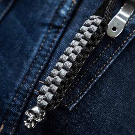 M-Tac Knife Lanyard Cuboid Skull, paracord ja koristeellinen pääkallohelmi vetoketjun edessä, tyylikäs ja käytännöllinen.