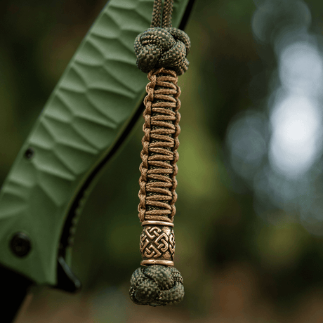 M-Tac Knife Lanyard Celtic, punottu paracord ja koristeellinen kelttikuvio, kiinnitetty veitsen kahvaan.