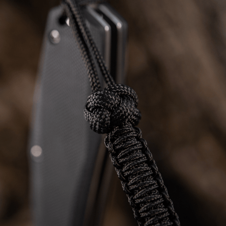 M-Tac Knife Lanyard Celtic, musta punottu paracord, korostaa veitsen muotoilua ja käytännöllisyyttä.