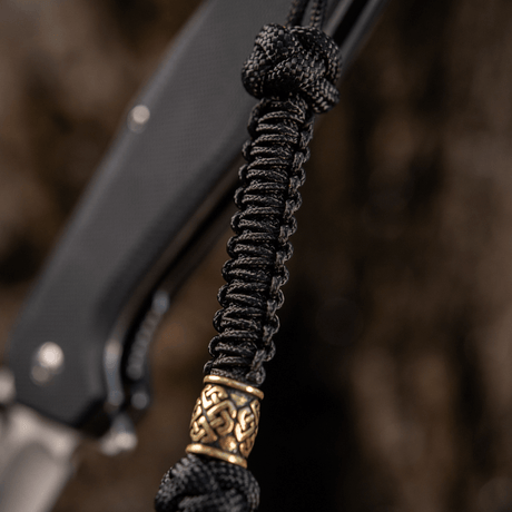 M-Tac Knife Lanyard Celtic, musta punos ja koristeellinen yksityiskohta, tekee veitsestä helpommin löydettävän ja tyylikkään.