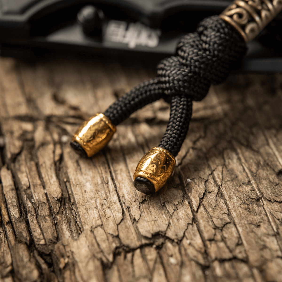 M-Tac Zeus Lanyard i flettet paracord-design, dekorativt og praktisk tilbehør med gyldne detaljer, ideel til kniv og udstyr.