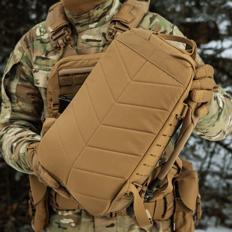 M-Tac reppu Sturm Elite Gen.II pidetään henkilön toimesta maastovarusteissa.
