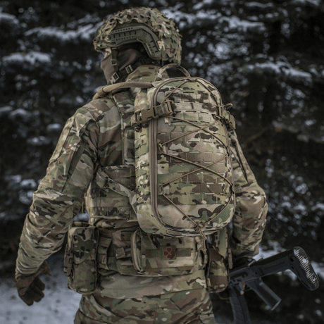 Sotilas kantaa M-Tac reppu Sturm Elite Gen.II lumisessa metsässä, MOLLE Laser Cut -järjestelmä ja joustonaru varusteille.