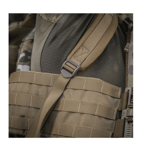 Ruskea M-Tac Large Assault Pack -reppu MOLLE-järjestelmällä ja säädettävillä olkahihnoilla, lähikuva kantohihnasta.