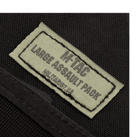 Lähikuva M-Tac Large Assault Pack -repun etiketistä, tuotemerkin logo ja nimi näkyvissä