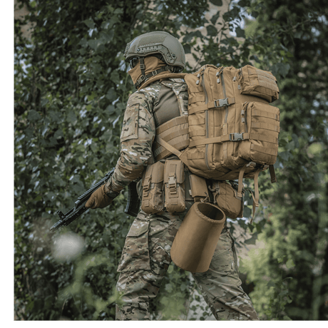 M-Tac Large Assault Pack -reppu käytössä henkilöllä maastopuvussa metsäympäristössä, MOLLE-järjestelmä ja säädettävät olkahihnat.