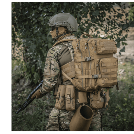 M-Tac Large Assault Pack -reppu MOLLE-järjestelmällä, kantaja maastokuosisessa univormussa puiden alla.