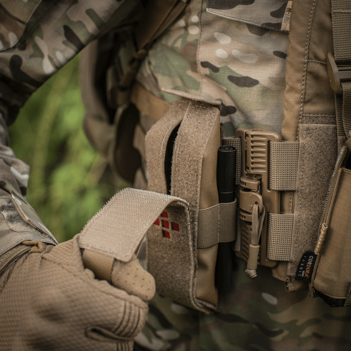 M-Tac Lomme til Tourniquet Closed i brug på taktisk vest i skovområde