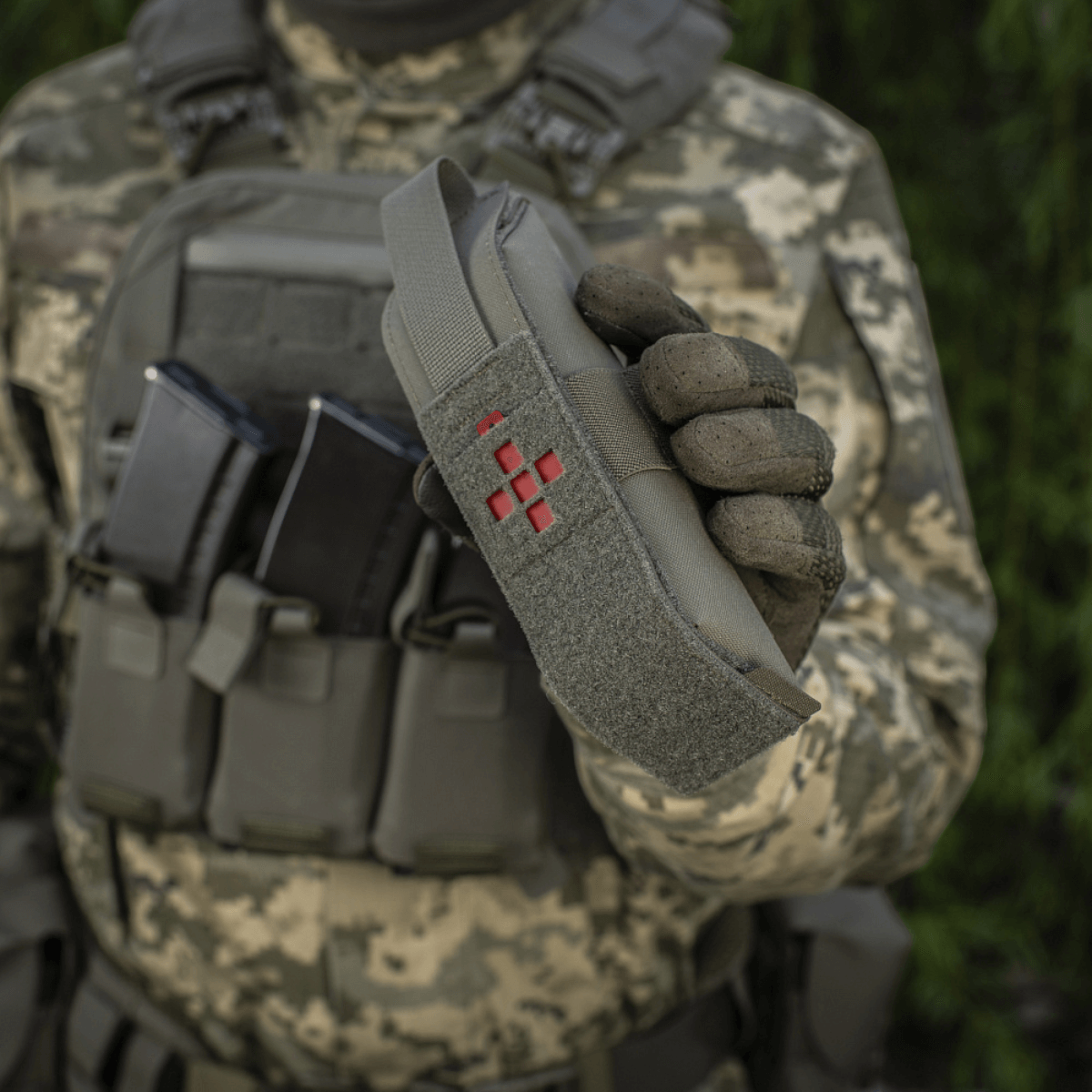 Soldat holder M-Tac Lomme til Tourniquet Closed i felten, med taktisk udstyr