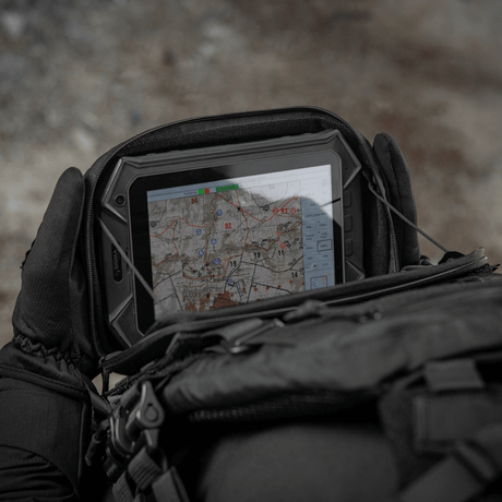 M-Tac Admin Pouch Large Elite käytössä maasto-olosuhteissa, säilyttää taktisia laitteita kuten tablettia ja karttoja.