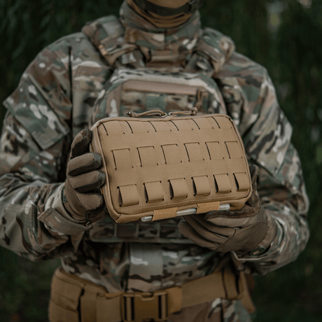 M-Tac Admin Pouch Large Elite käytössä, pidetty henkilön toimesta maastopuvussa. Kätevä taktisten varusteiden säilytykseen, valmistettu Cordura 500D:stä.