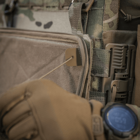 Lähikuva M-Tac Admin Pouch Large Elite kiinnitettynä taktiseen varusteeseen, hansikkaalla olevan käden säätäessä hihnaa.