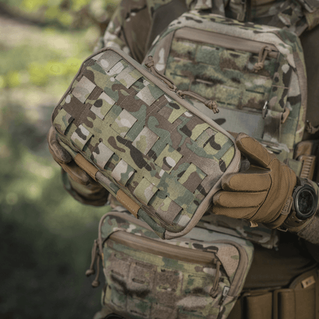 M-Tac Admin Pouch Large Elite käytössä, taktista varustusta kantava henkilö pitää sitä, camouflagemalli, Cordura 500D -materiaali.